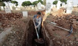 Suriye ordusunun yetim bıraktığı Halepli çocuk ailesine bakabilmek için mezar kazıyor