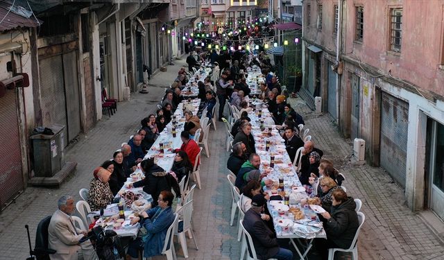 Mahalleli fazladan yaptığı yemekleri sokakta kurulan iftar sofrasında paylaşıyor